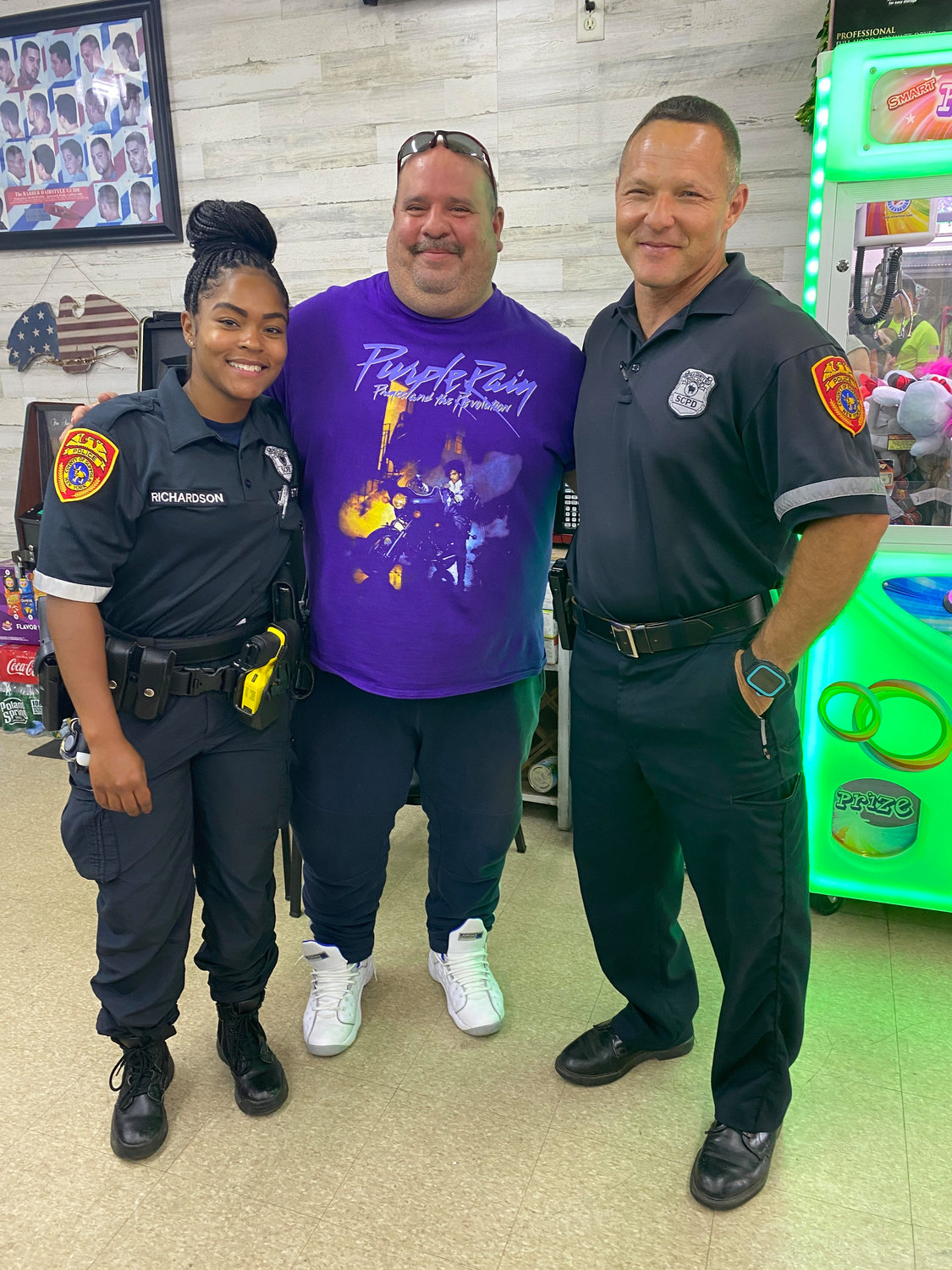 Officer Richardson, of the Suffolk County Community Relations Bureau; Jeffrey Manzolillo, owner of Jenny’s JNT Beauty Barbershop; and Officer Frank Raspanti, community liaison for the 7th Precinct.